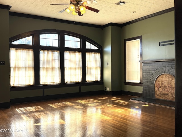 unfurnished living room with ceiling fan, ornamental molding, dark hardwood / wood-style flooring, and a brick fireplace