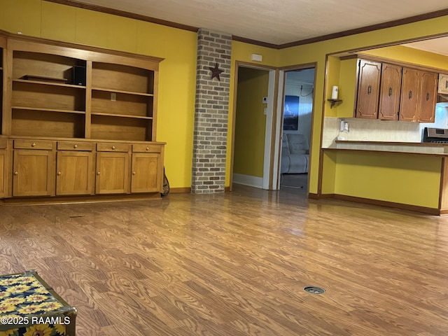 unfurnished living room featuring crown molding and light wood-type flooring