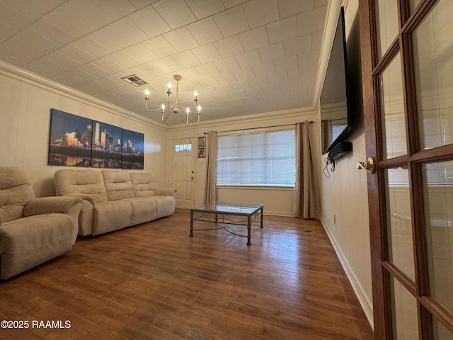 living room featuring an inviting chandelier, hardwood / wood-style floors, and ornamental molding