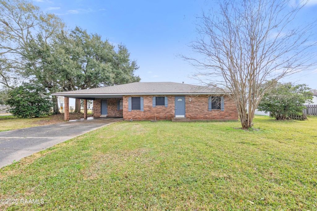 ranch-style house featuring a carport and a front yard