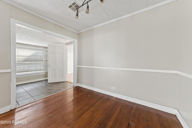 spare room featuring hardwood / wood-style flooring and ornamental molding