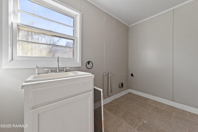 clothes washing area with sink and crown molding