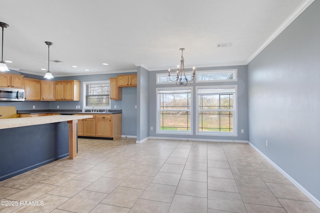 kitchen featuring crown molding, tile counters, an inviting chandelier, and hanging light fixtures