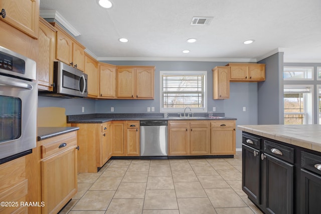 kitchen featuring light tile patterned floors, crown molding, sink, appliances with stainless steel finishes, and light brown cabinetry