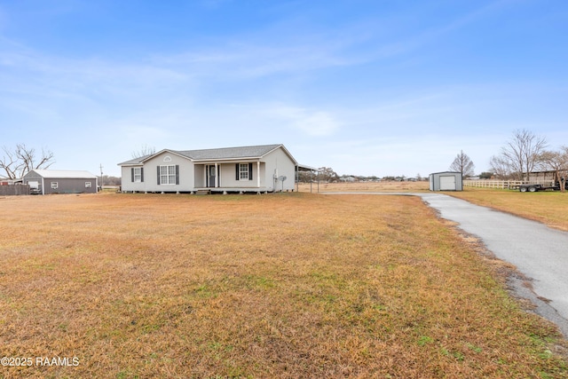 view of front of home featuring a storage shed and a front lawn