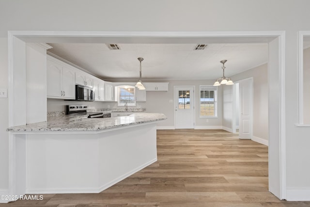 kitchen featuring sink, appliances with stainless steel finishes, hanging light fixtures, white cabinets, and kitchen peninsula