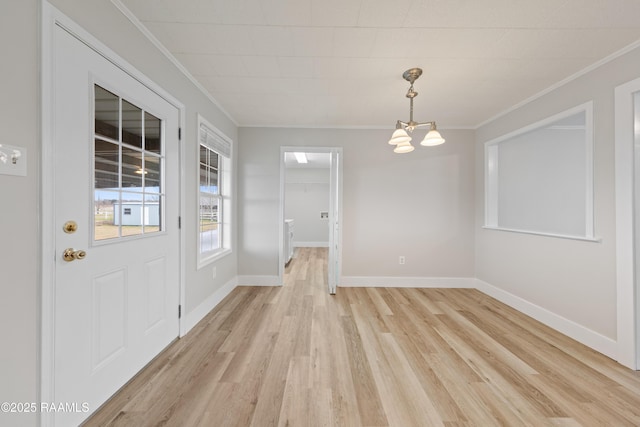 unfurnished dining area featuring crown molding, a notable chandelier, and light hardwood / wood-style flooring