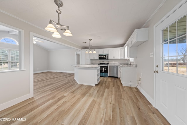 kitchen with pendant lighting, appliances with stainless steel finishes, a notable chandelier, light hardwood / wood-style floors, and white cabinets