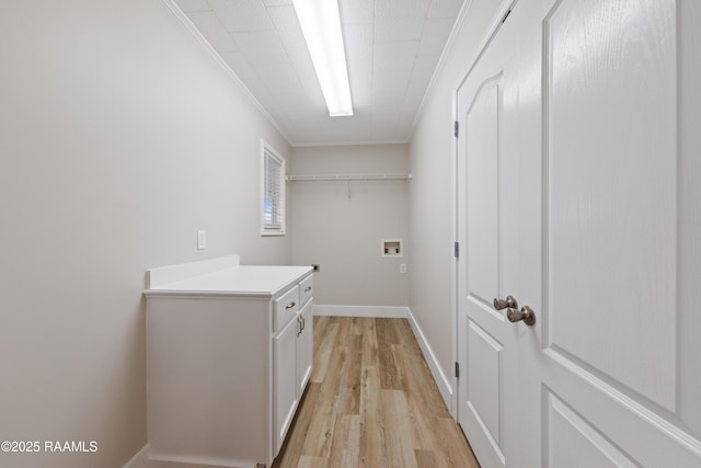 washroom with hookup for a washing machine, crown molding, cabinets, and light hardwood / wood-style floors