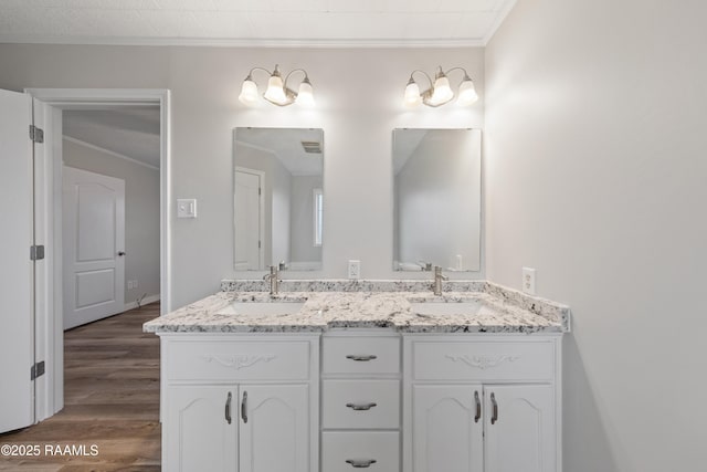 bathroom with hardwood / wood-style flooring, ornamental molding, and vanity