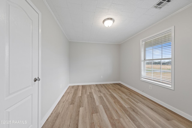 unfurnished room with ornamental molding and light wood-type flooring