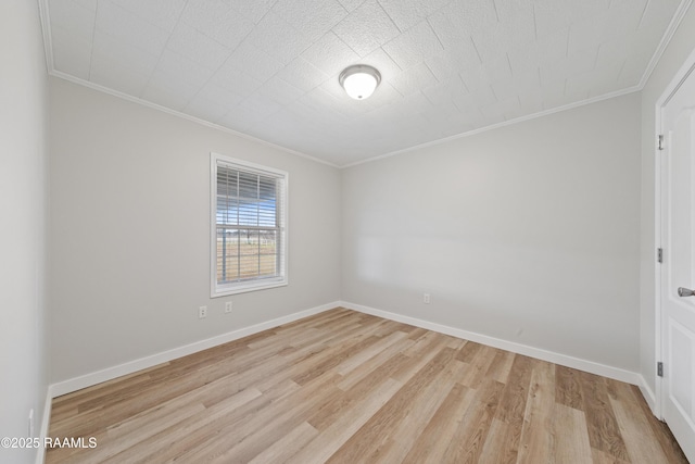 spare room with crown molding and light wood-type flooring