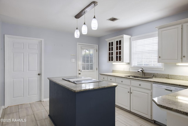 kitchen featuring pendant lighting, dishwasher, white cabinetry, sink, and a center island