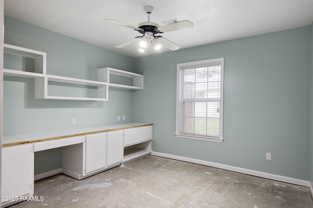 unfurnished office with ceiling fan and built in desk