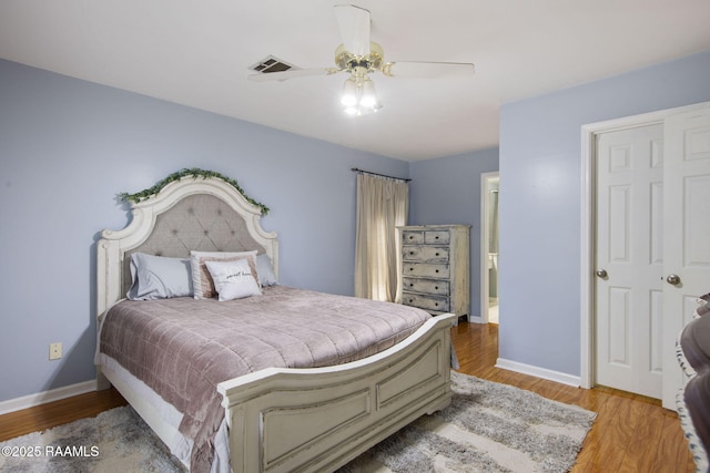 bedroom with connected bathroom, light hardwood / wood-style floors, and ceiling fan