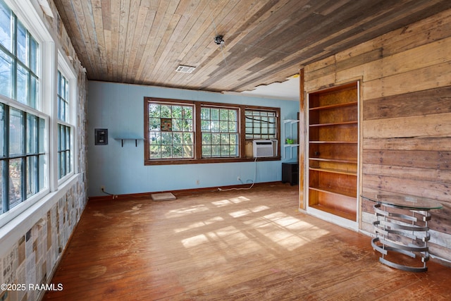 empty room with hardwood / wood-style flooring, cooling unit, and wooden ceiling