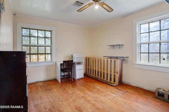 bedroom featuring light hardwood / wood-style flooring, ornamental molding, and a wall mounted AC