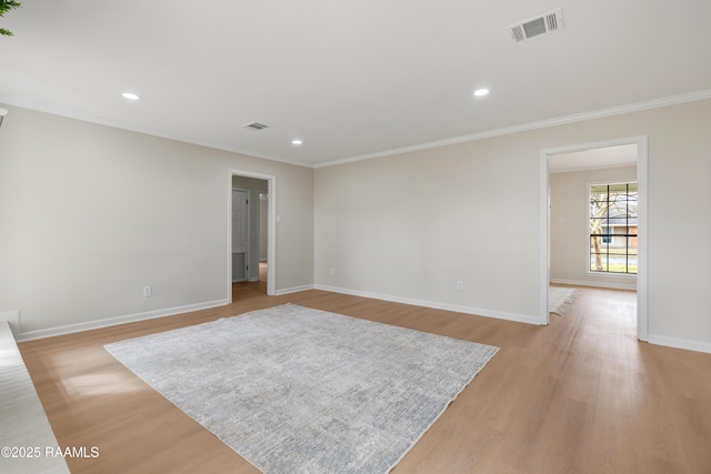 empty room featuring light hardwood / wood-style flooring and ornamental molding