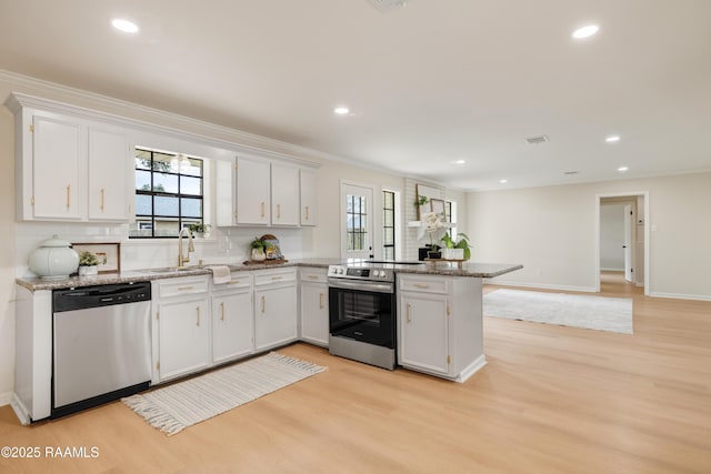 kitchen with stainless steel appliances, white cabinets, and kitchen peninsula