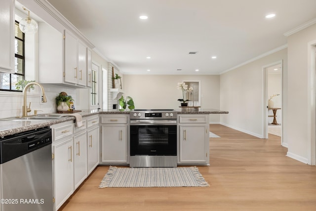 kitchen featuring white cabinetry, stainless steel appliances, kitchen peninsula, and sink