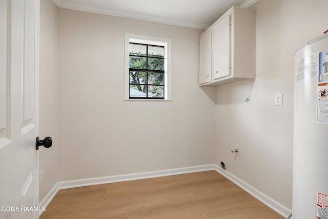 laundry area with water heater, ornamental molding, light wood-type flooring, and cabinets