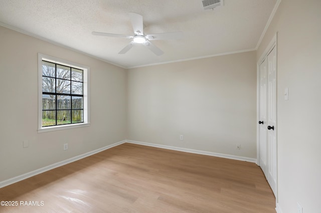 unfurnished room featuring crown molding, ceiling fan, a textured ceiling, and light hardwood / wood-style floors