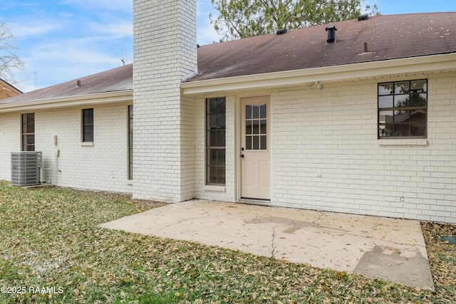 back of property with a patio, a yard, and central air condition unit