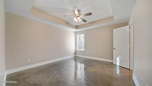 unfurnished room with a raised ceiling and ceiling fan