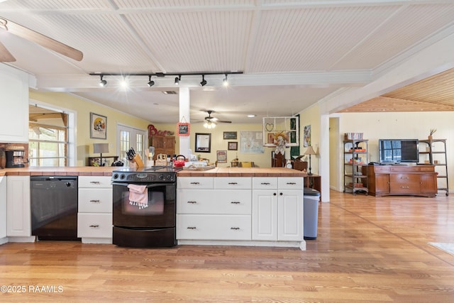 kitchen featuring light wood-style flooring, open floor plan, white cabinetry, tile counters, and black appliances