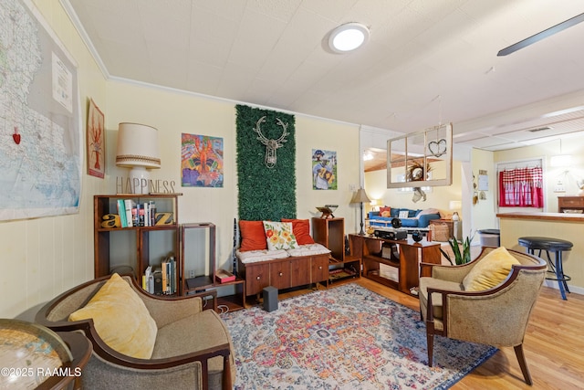 sitting room featuring ornamental molding and wood finished floors