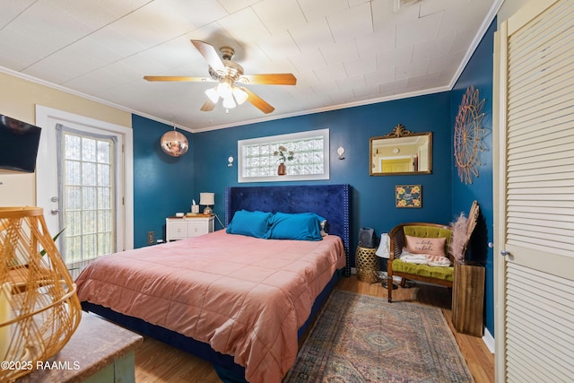 bedroom with a ceiling fan, crown molding, and wood finished floors