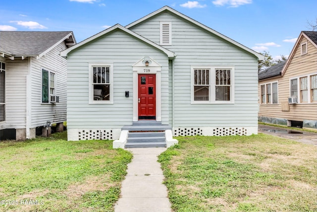 bungalow-style home with cooling unit and a front lawn