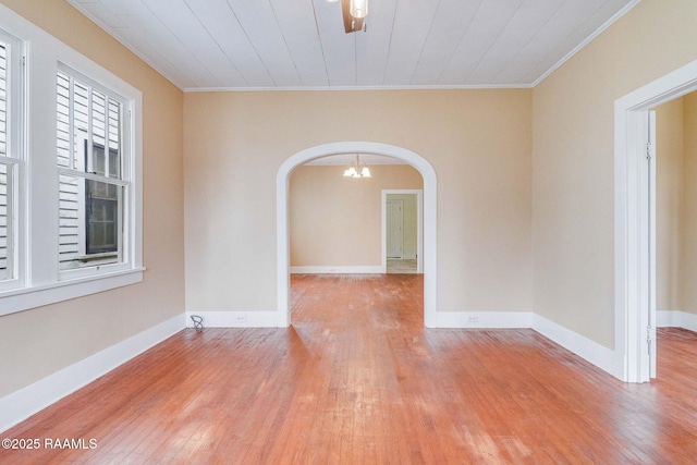 unfurnished room featuring crown molding, light hardwood / wood-style flooring, and a chandelier