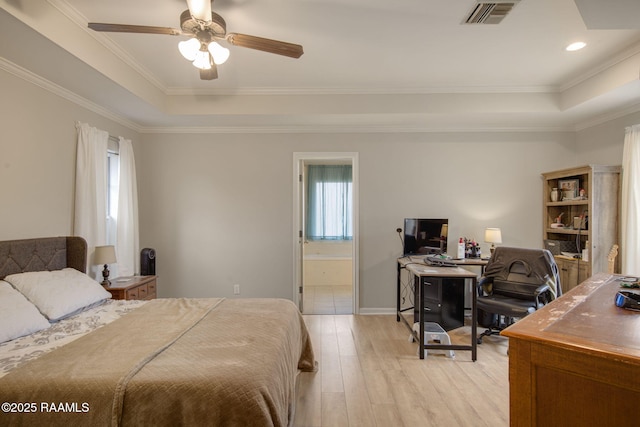 bedroom with ornamental molding, light wood-type flooring, a raised ceiling, and visible vents