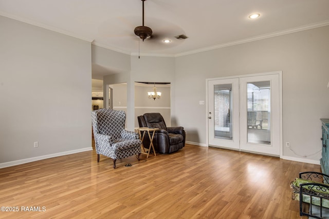 sitting room featuring light wood-style floors, ornamental molding, and baseboards