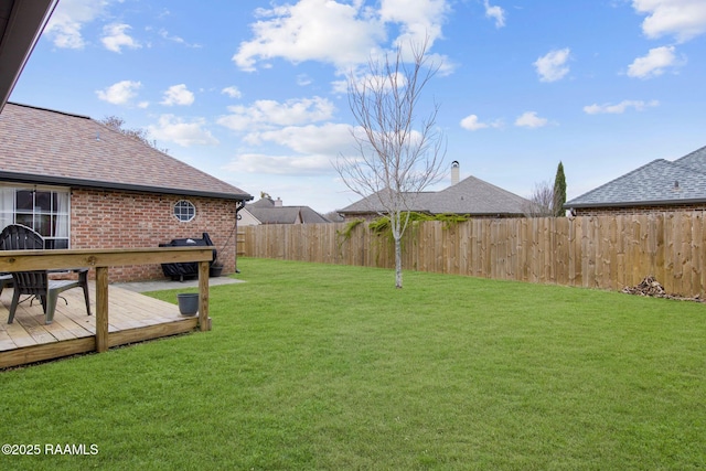 view of yard featuring fence and a deck