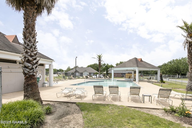 community pool with a patio area, fence, and a gazebo