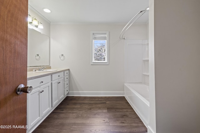 bathroom with ornamental molding, shower / bathing tub combination, wood-type flooring, and vanity