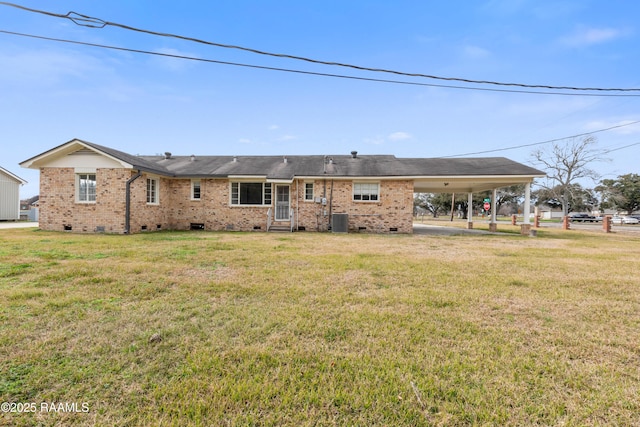 rear view of house featuring central AC unit, a lawn, and a carport