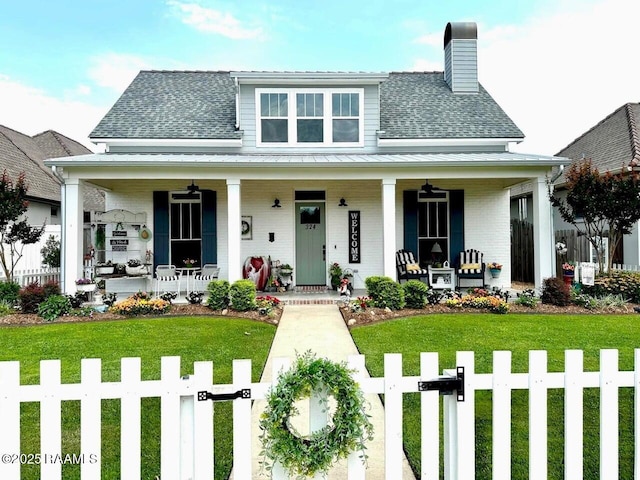 view of front of home featuring ceiling fan, covered porch, and a front yard