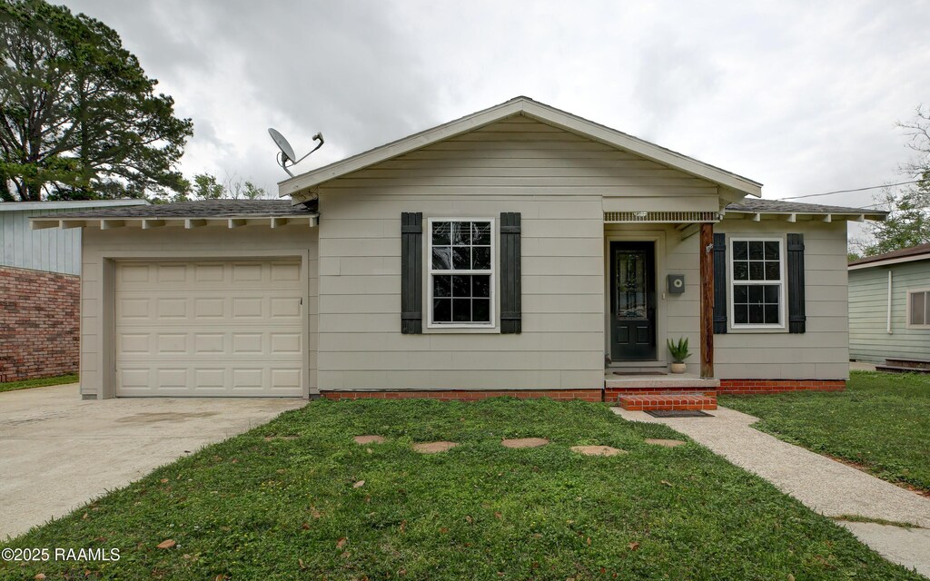 ranch-style home with driveway, a front yard, and a garage
