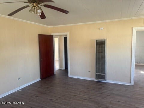 empty room with crown molding, ceiling fan, and dark wood-type flooring