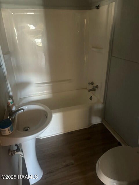 bathroom featuring shower / bath combination, hardwood / wood-style flooring, and toilet