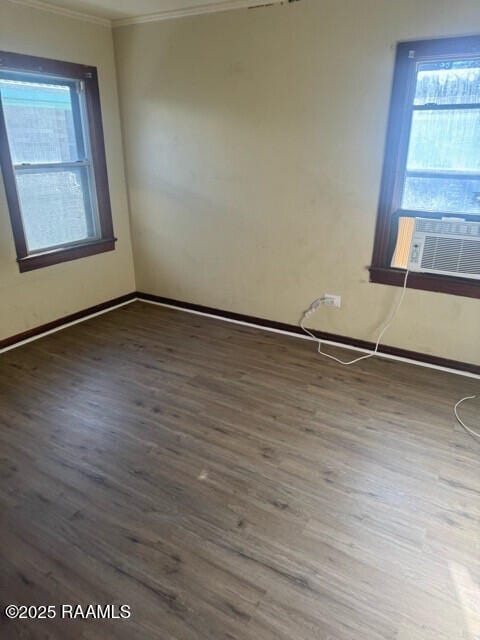 empty room featuring hardwood / wood-style flooring, crown molding, and cooling unit