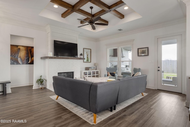 living room with dark wood-type flooring, coffered ceiling, beam ceiling, crown molding, and a fireplace