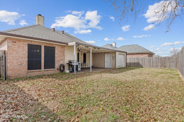 rear view of house featuring ceiling fan, a yard, and a patio area