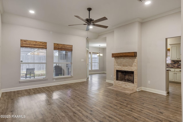 unfurnished living room featuring dark hardwood / wood-style floors, ceiling fan, ornamental molding, and a fireplace