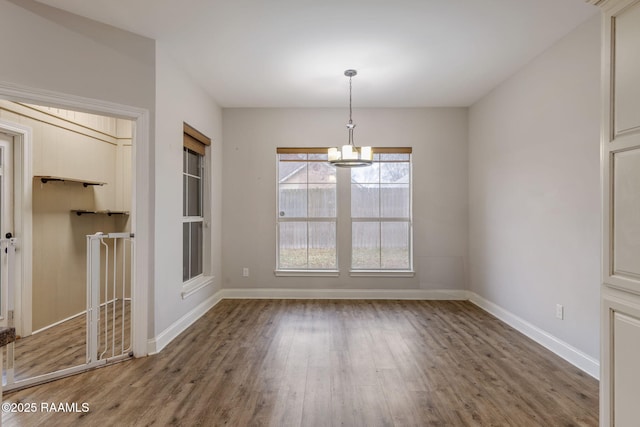 unfurnished dining area with hardwood / wood-style flooring and a chandelier