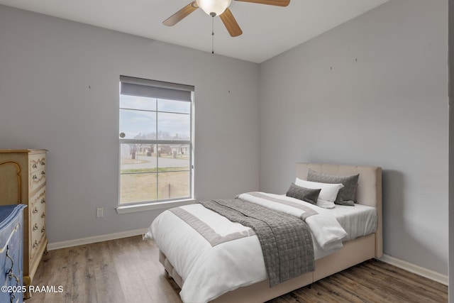 bedroom featuring multiple windows, hardwood / wood-style flooring, and ceiling fan