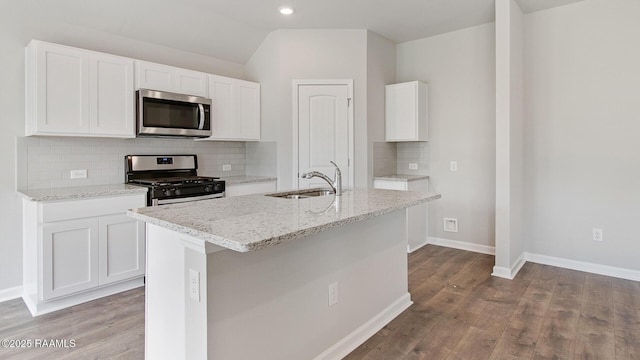 kitchen with sink, appliances with stainless steel finishes, an island with sink, light stone countertops, and white cabinets